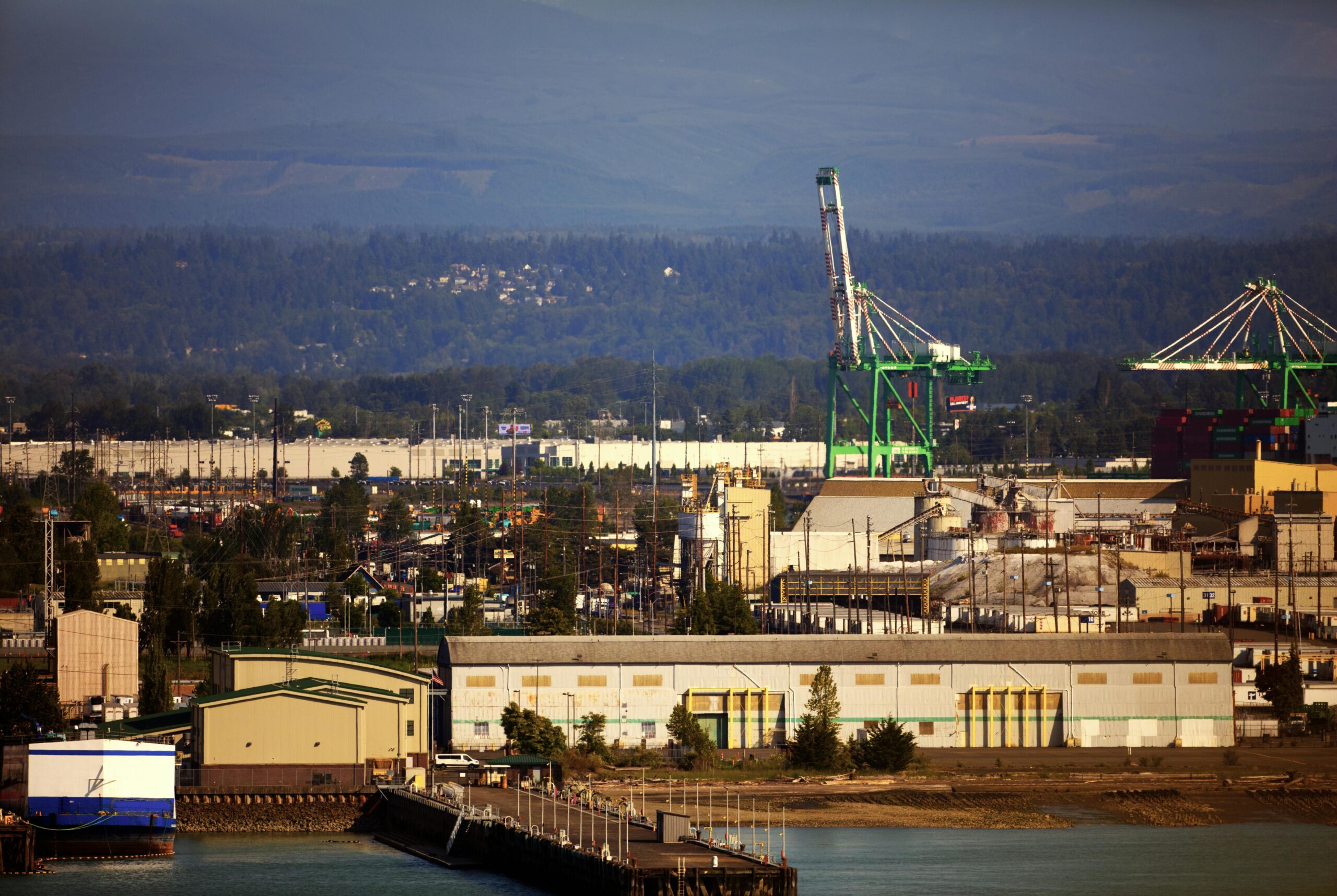 A scenic view of an industrial port with cranes and warehouses at daytime.