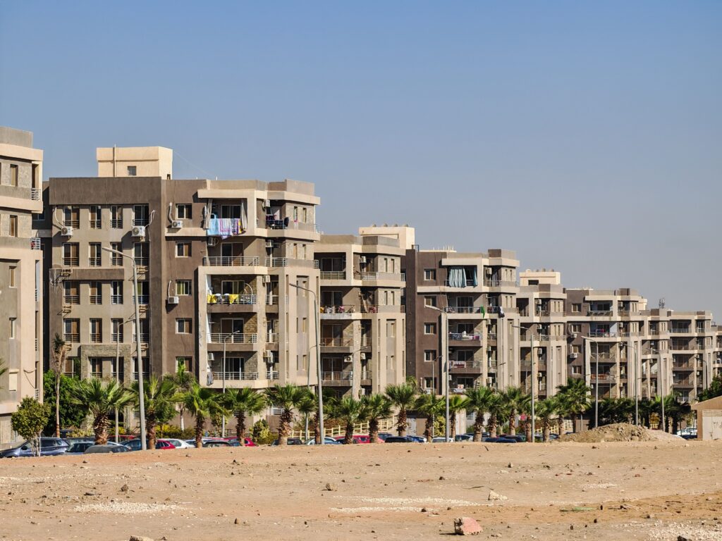 Contemporary apartment buildings under clear skies in Giza, showcasing urban architecture.