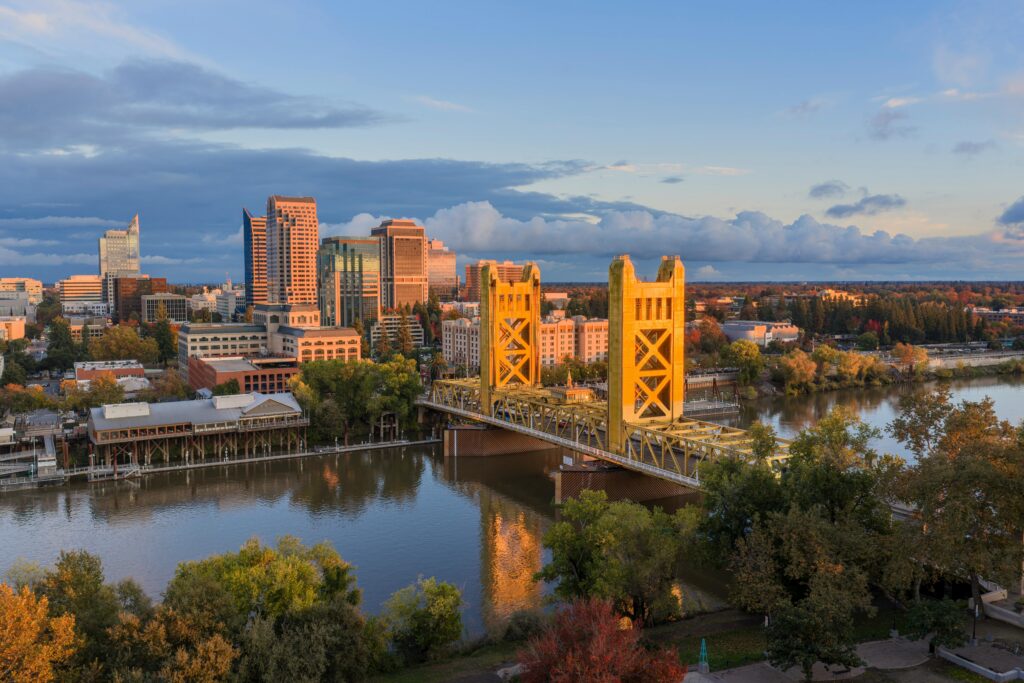 Beautiful scenic aerial view of Sacramento's iconic Tower Bridge at sunset with city skyline.