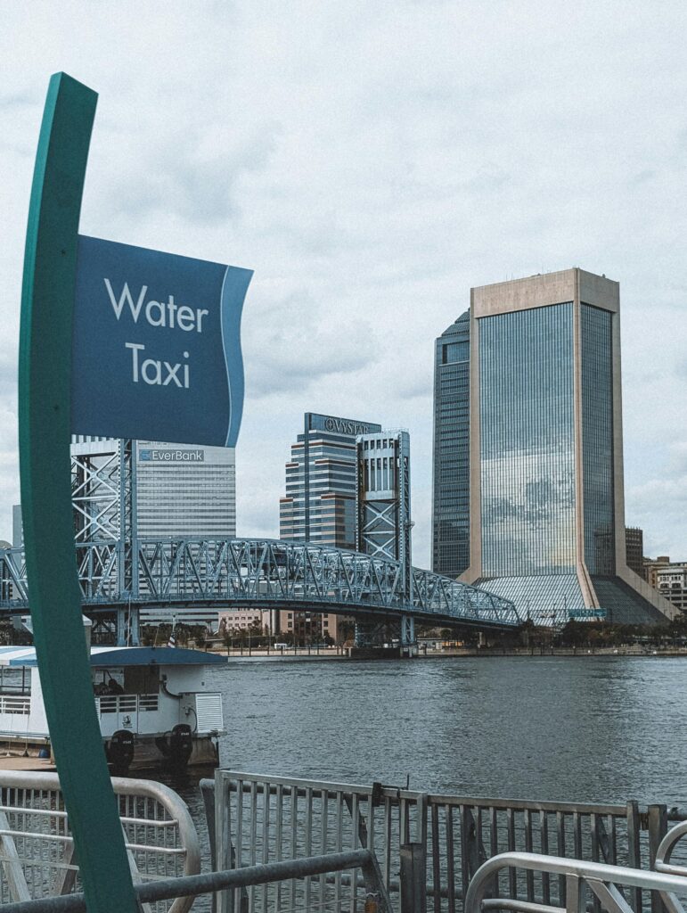 View of Jacksonville's skyline featuring the Main Street Bridge and a water taxi sign.