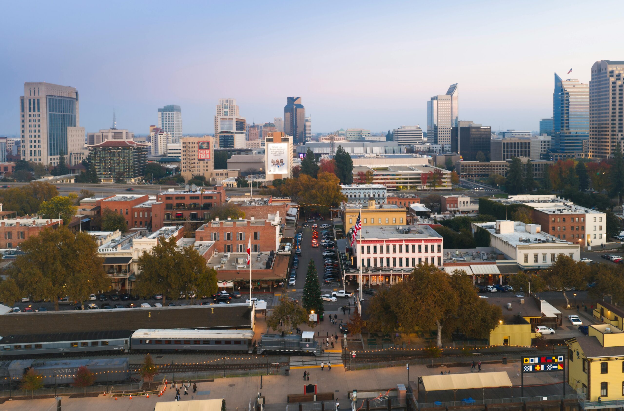 Aerial view of Sacramento cityscape featuring downtown skyline and historic buildings during twilight.