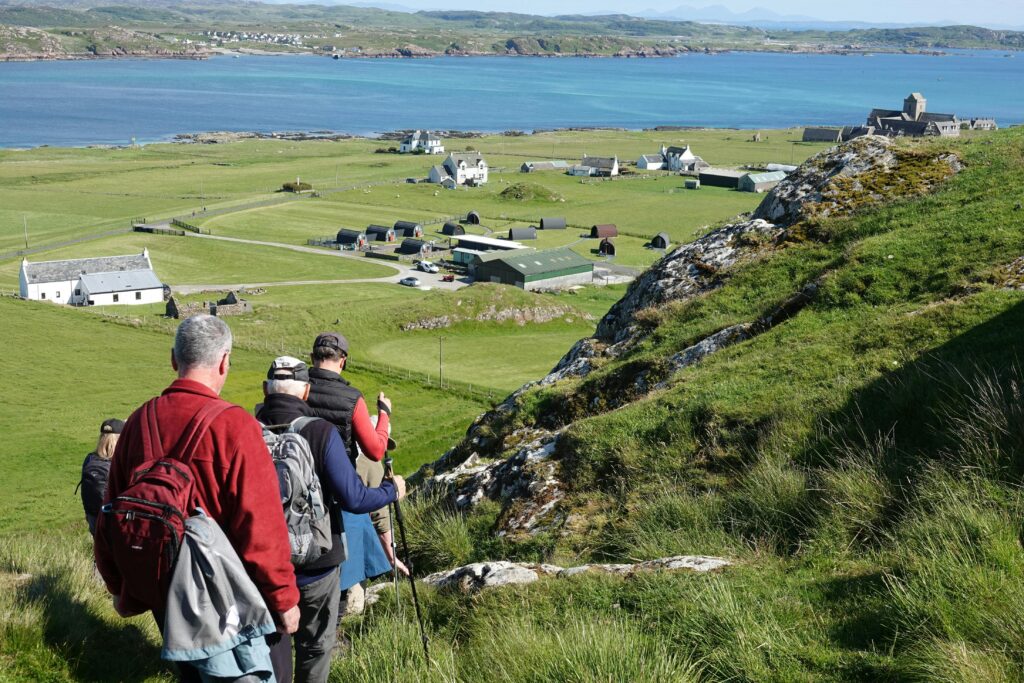 Group hiking through scenic Scottish countryside with stunning coastal views.