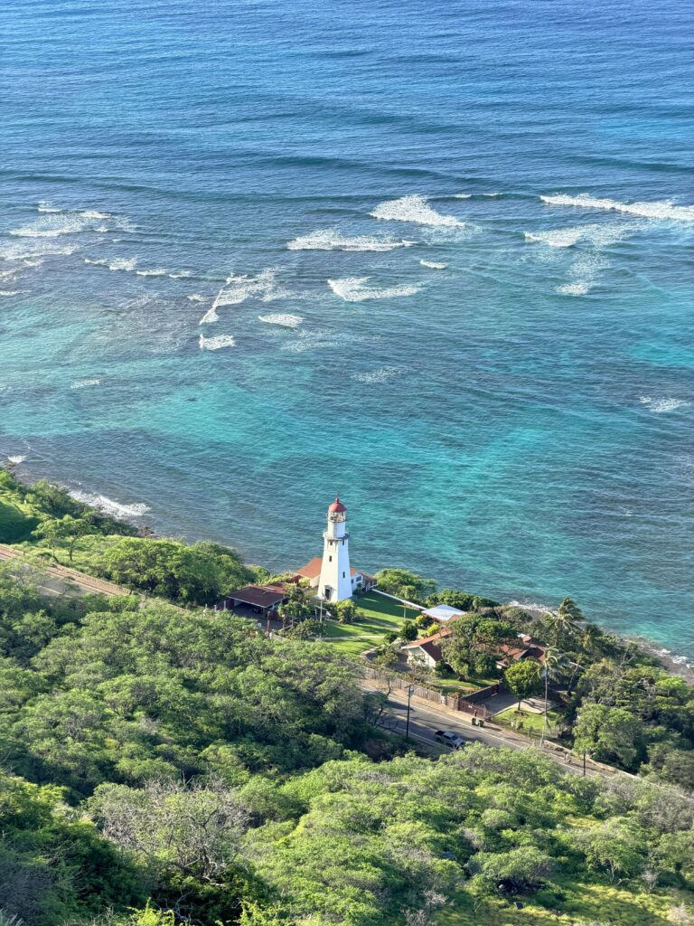 Stunning aerial photo of Diamond Head Lighthouse against turquoise waters in Hawaii.