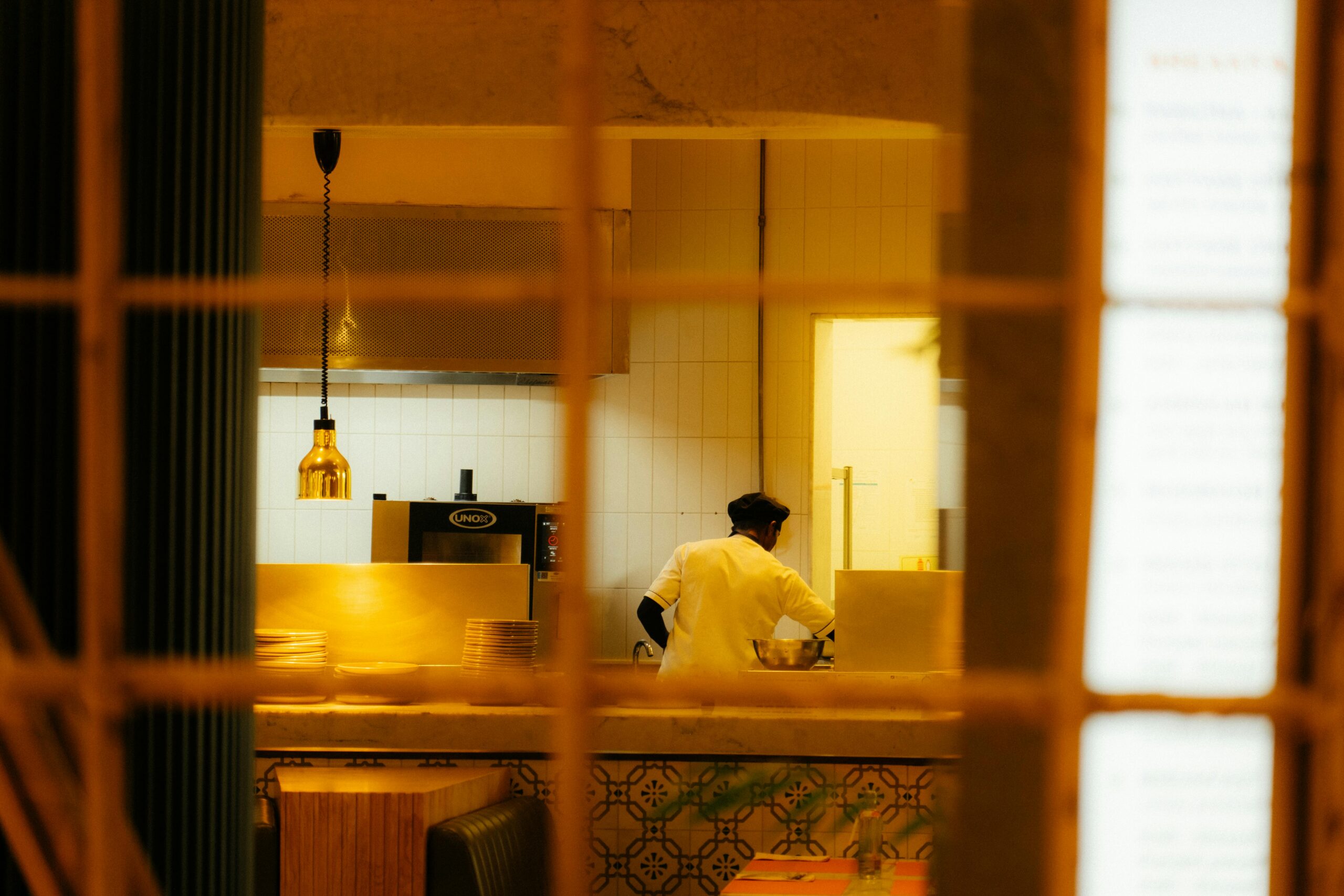 A professional chef preparing food in a warm, inviting restaurant kitchen at night.