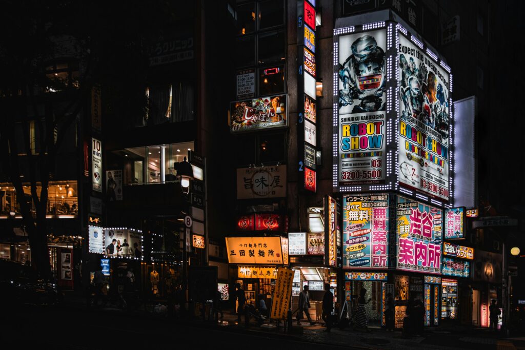 Bright neon signs illuminate the bustling streets of Shinjuku at night, capturing Tokyo's vibrant nightlife.