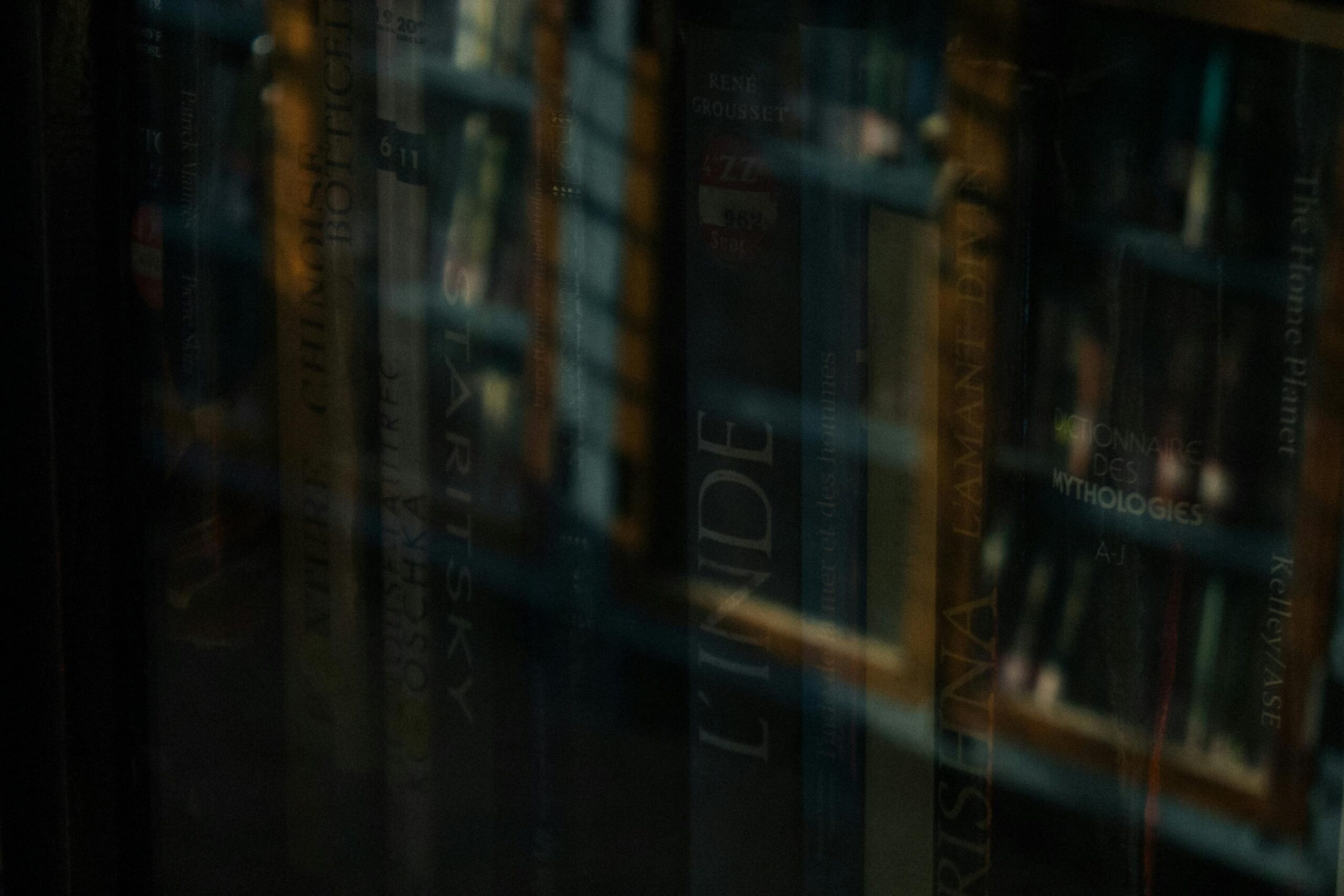 Through glass high angle of stack of books on shelf of literary store