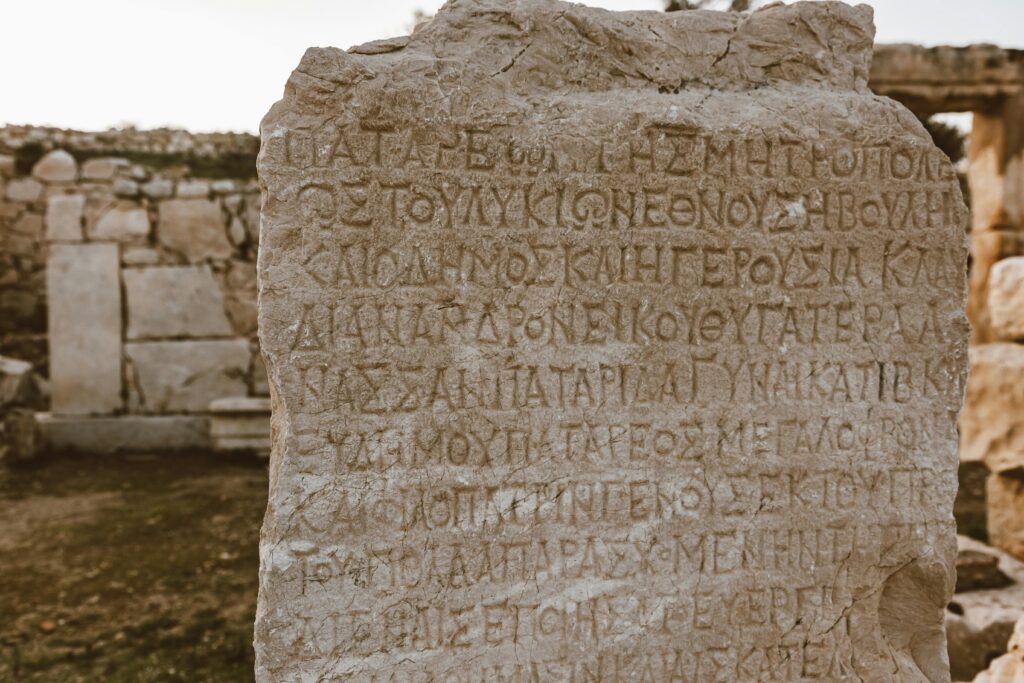 Close-up of an ancient Greek inscribed stone in an archaeological site.
