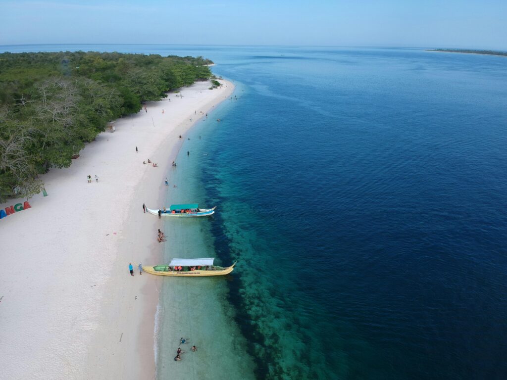 Discover the serene white sand beach and vibrant blue waters of Zamboanga, captured from above.