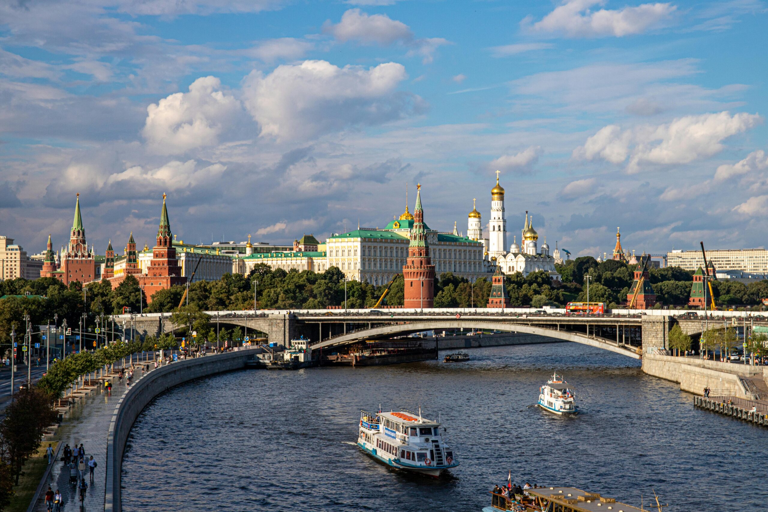 Scenic view of the Moscow Kremlin and architecture with boats on the Moskva River.