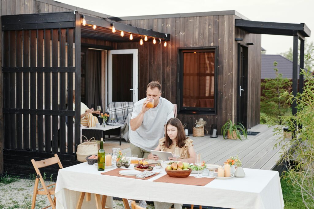 Couple enjoying an intimate evening meal outdoors on a stylish wooden deck with modern accents.