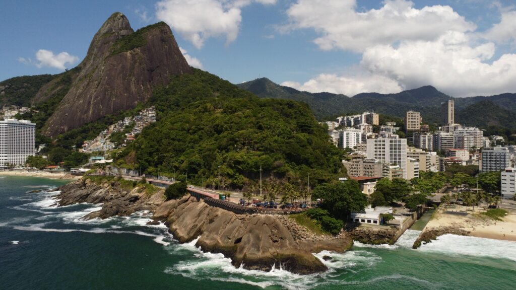 Stunning aerial view of Vidigal Beach with lush greenery and cityscape in Rio de Janeiro, Brazil.