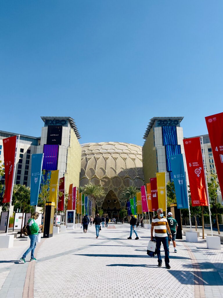 Colorful banners lead to the striking pavilion at Expo 2020 Dubai, capturing urban vibrancy.