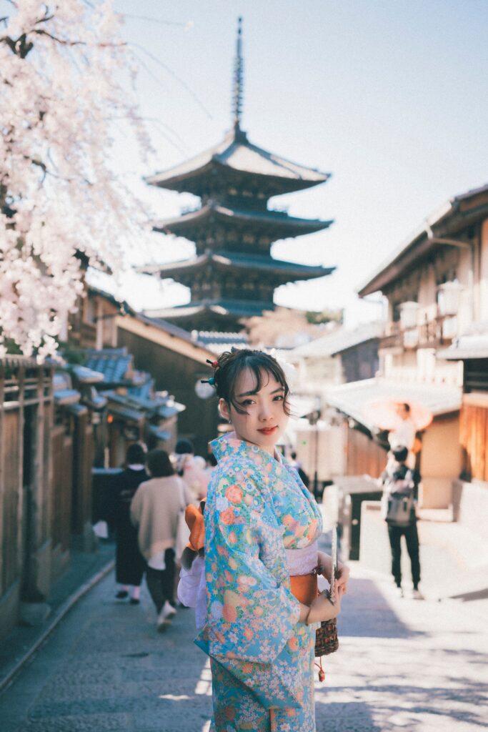 Woman in traditional kimono near Kyoto pagoda, capturing Japanese culture and spring beauty.
