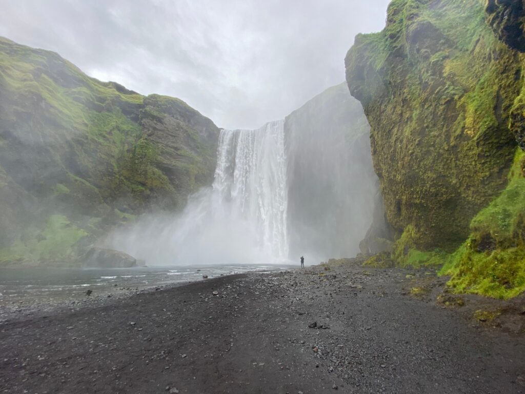 Breathtaking view of Skogafoss waterfall in Iceland with lush green cliffs.