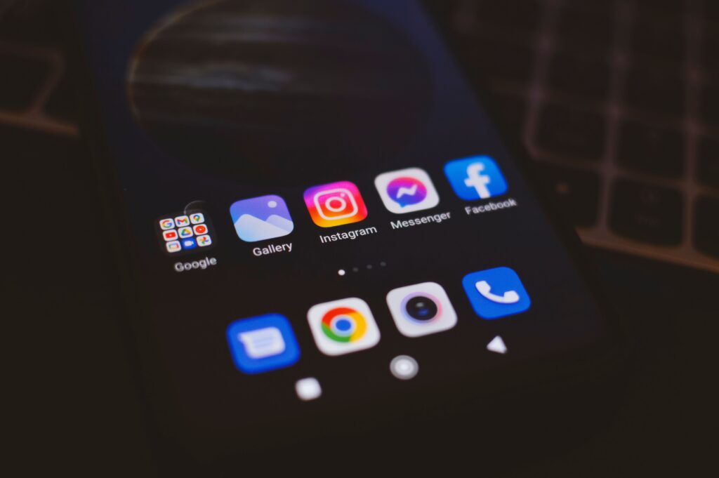 A smartphone displaying popular social media apps in a dimly lit environment, perfect for tech and communication themes.