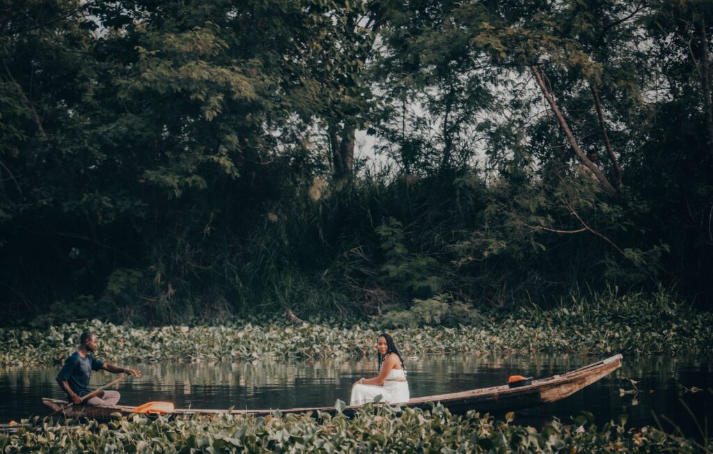Serene scene of people on a boat surrounded by greenery, showcasing nature's beauty.
