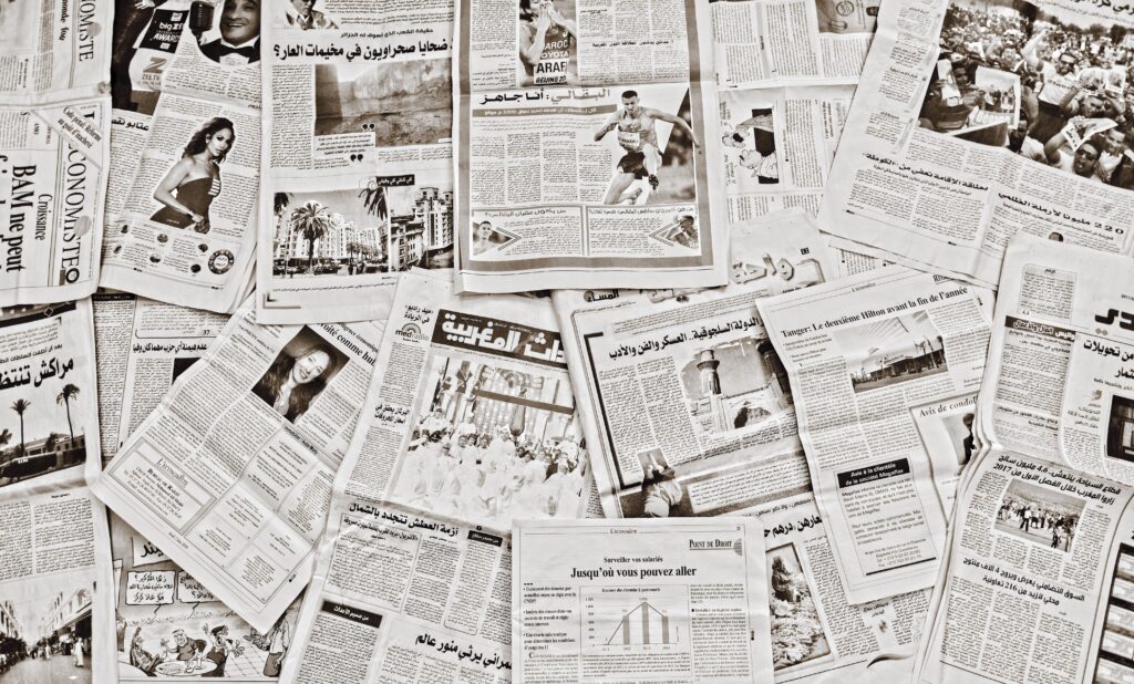 A flat lay of Arabic newspapers in Fès, Morocco, showcasing diverse articles.
