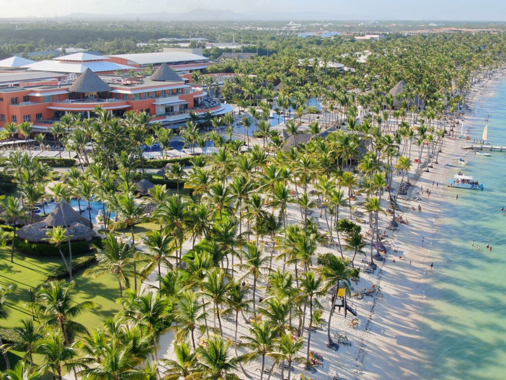 Aerial view of a tropical beach resort lined with palm trees and sandy beaches.