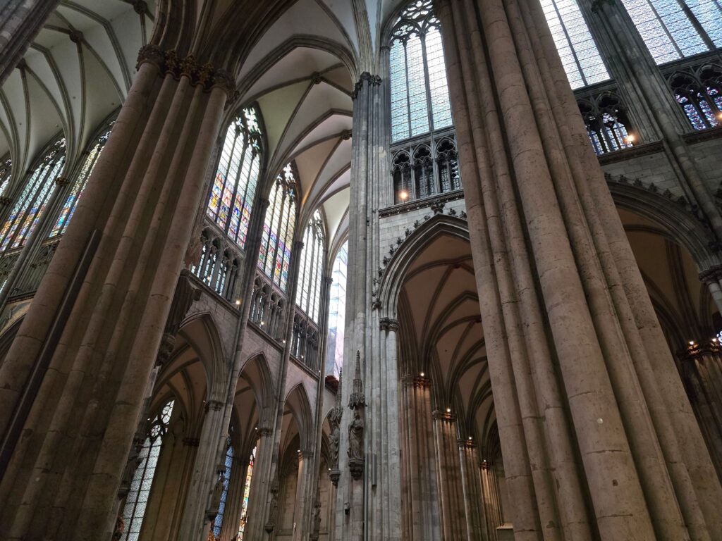 Intricate Gothic architecture of Cologne Cathedral with towering arches and stained glass windows.