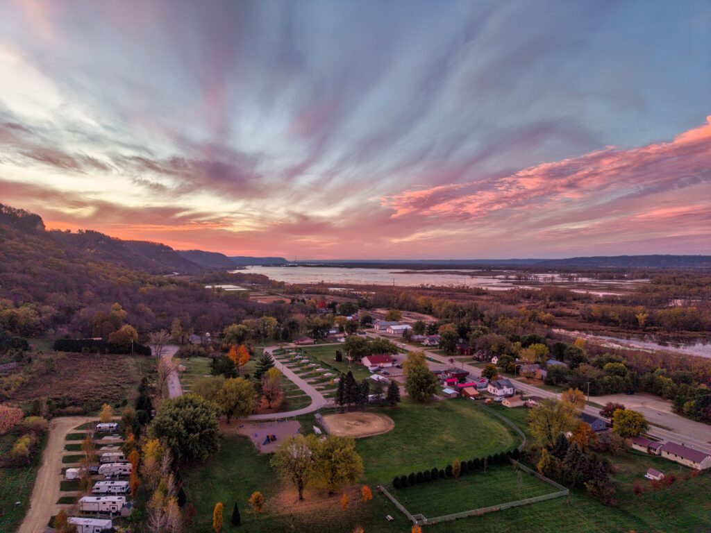 Aerial view of Nelson, Wisconsin at sunset with vivid sky and lush landscape.