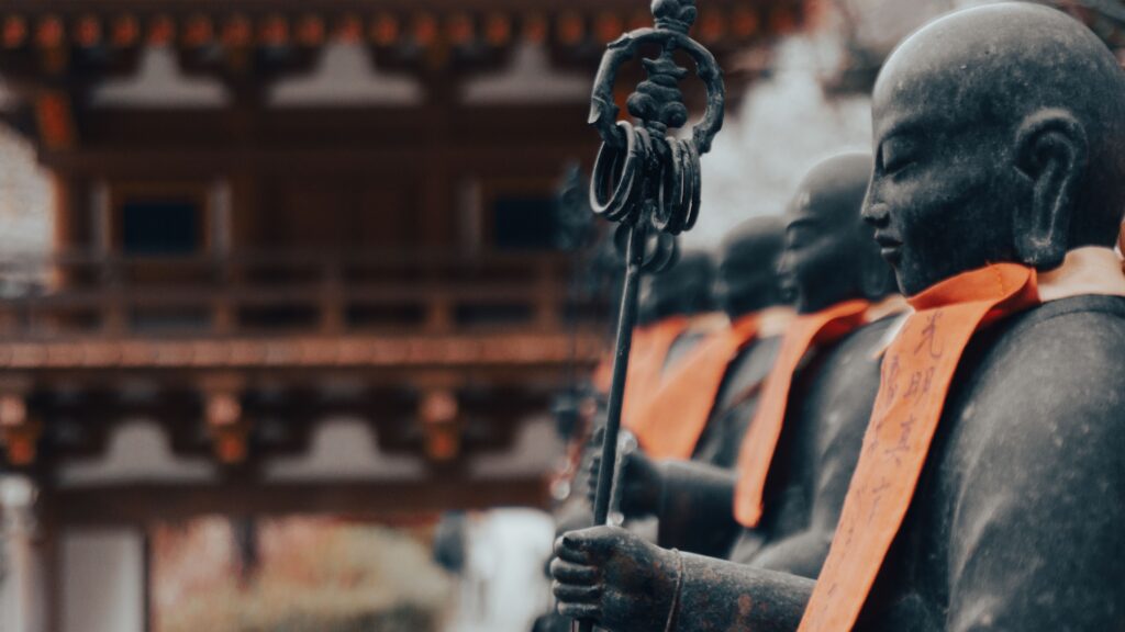 Buddhist statues with vibrant sashes at a temple in Nara, Japan, emphasizing tranquility and culture.
