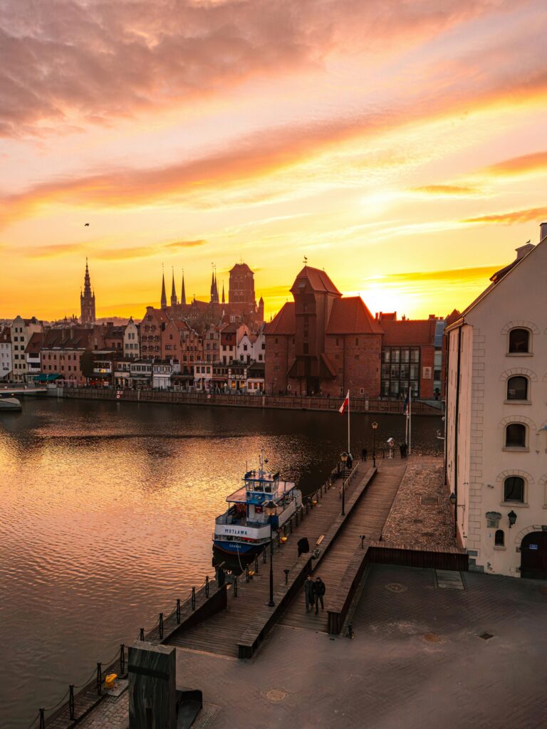 Breathtaking sunset over Gdańsk Old Town, capturing vibrant skies and historic architecture along the river.