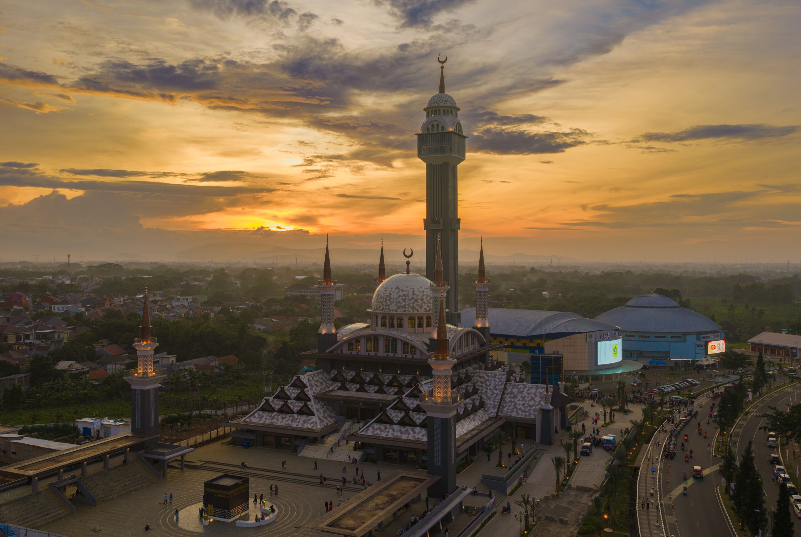 A stunning aerial shot of a mosque during sunset, showcasing its architecture and surrounding landscape.