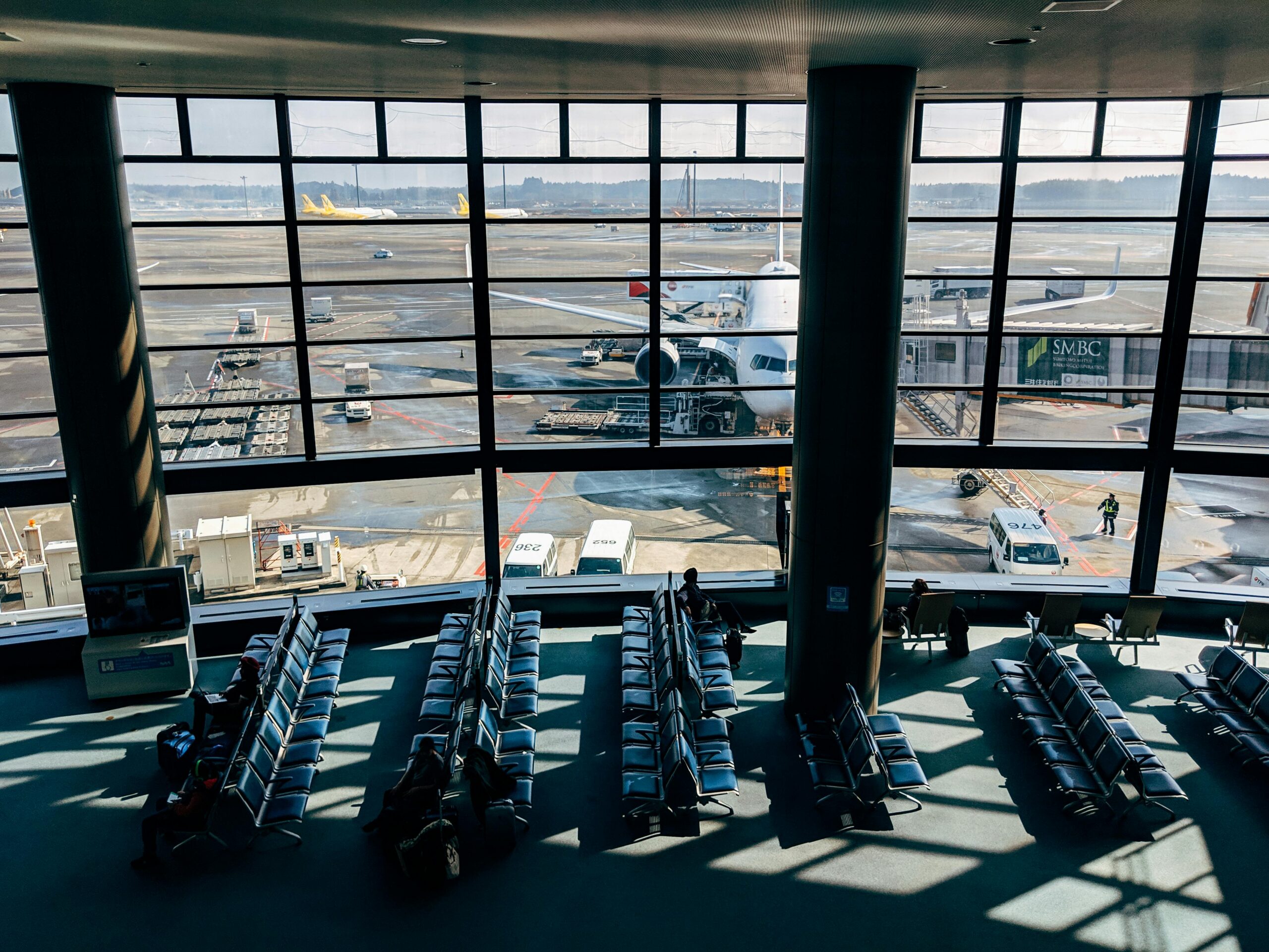 Spacious airport terminal with airplane and tarmac view in Tokyo, Japan.