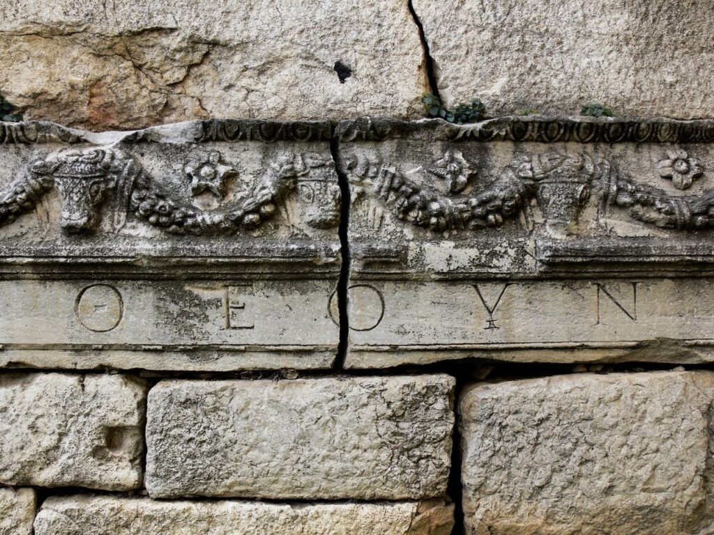 Close-up of an ancient Roman stone wall with decorative carvings and visible cracks in Bursa.
