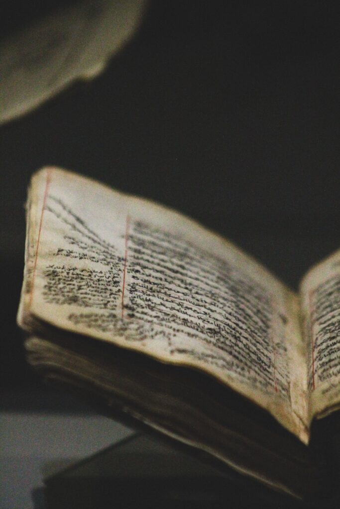 Close-up of an open antique manuscript showcasing detailed handwritten script with historical significance.