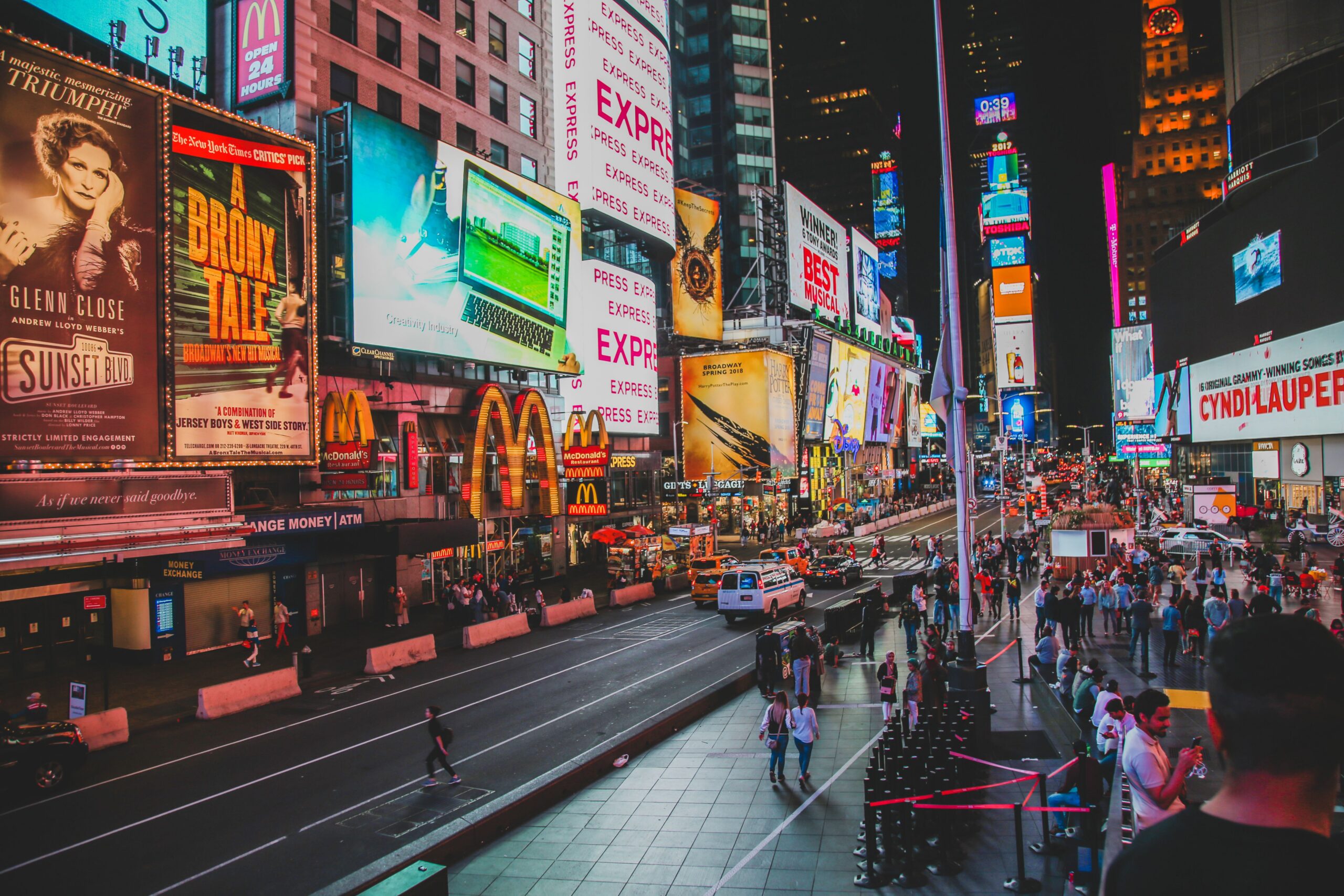 Dynamic view of Times Square nightlife with crowds and illuminated billboards in New York City.