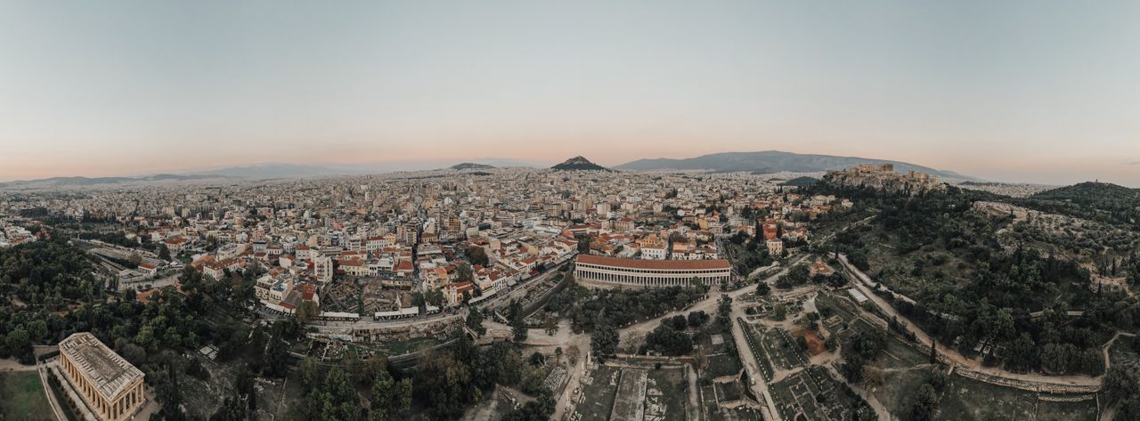 A stunning aerial view of Athens cityscape at sunrise, showcasing historical landmarks.