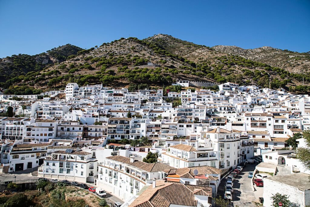 Charming view of a whitewashed Spanish town nestled in the hills during a sunny day.