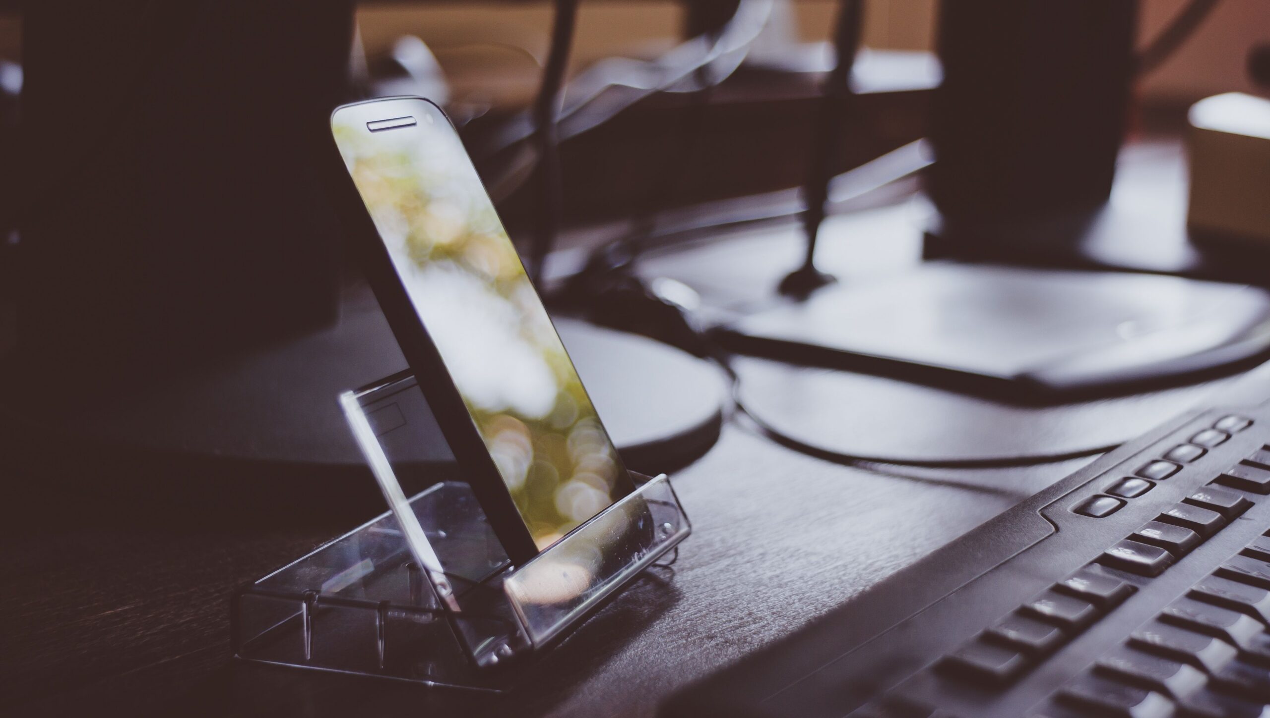 Workspace with smartphone on stand and keyboard, highlighting modern technology and productivity.