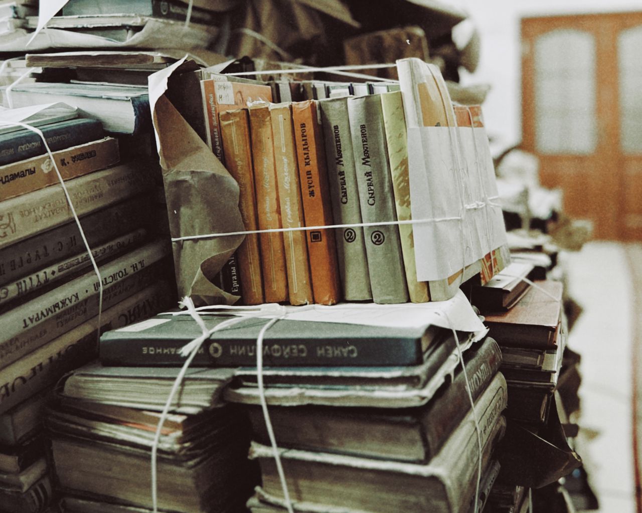 A stack of vintage books tied with string in Talgar, Kazakhstan library.