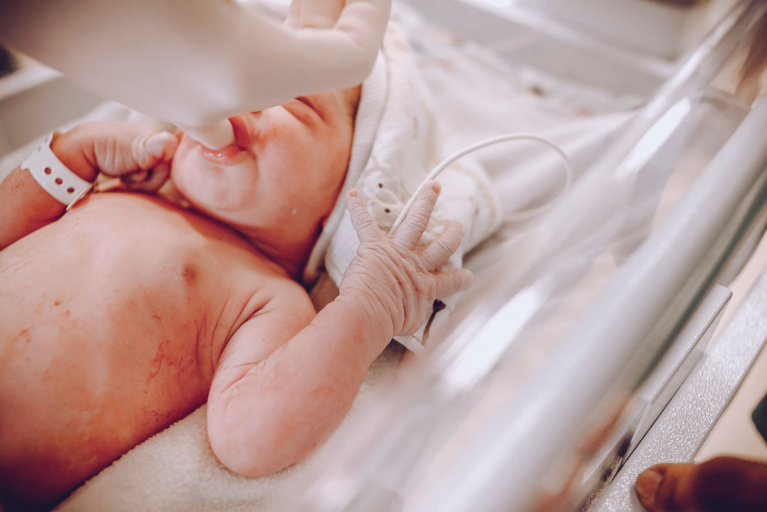 A newborn baby in a hospital setting receiving care with a focus on wellness and health.