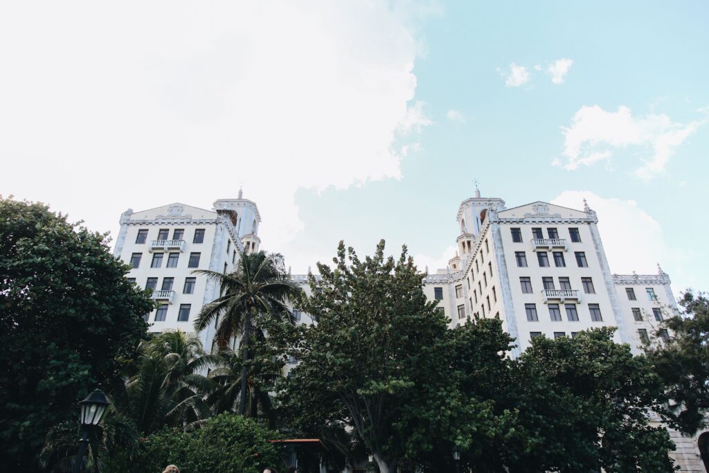Majestic colonial building set against a vibrant sky and surrounded by tropical trees in a serene cityscape.