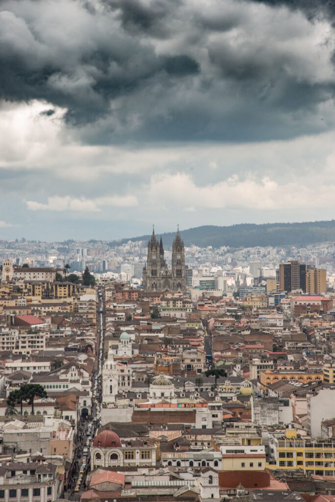 View of Quito's historic center with dramatic clouds and urban landscape.