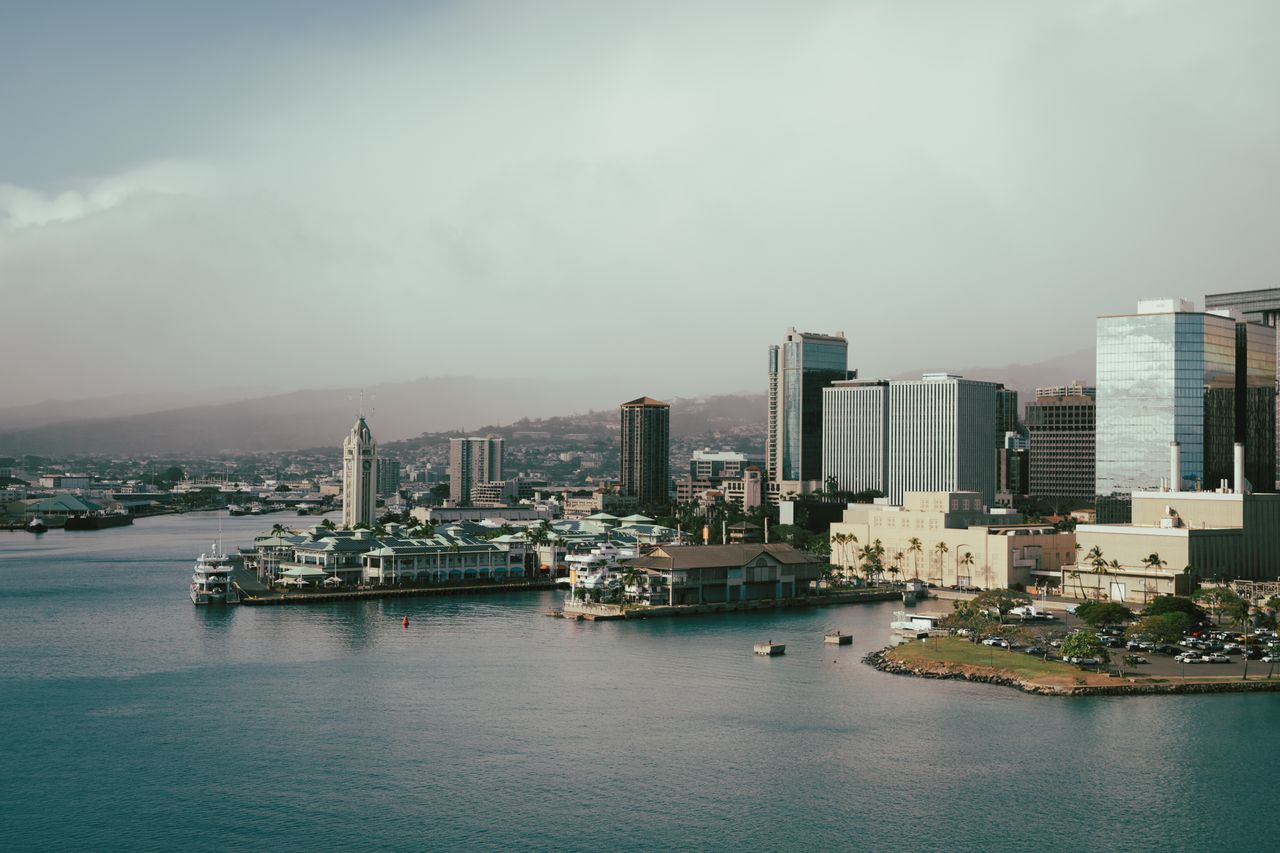 A scenic view of Honolulu's cityscape with waterfront buildings and a vibrant skyline.