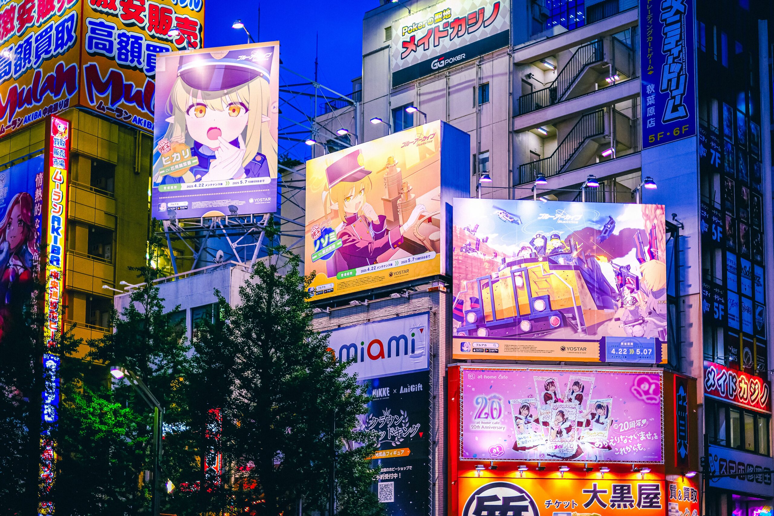 Bright anime billboards illuminate the night in Akihabara, Tokyo, showcasing the vibrant nightlife.