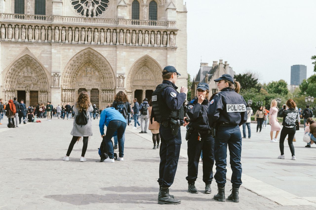 Police officers in uniform stand outside Notre Dame Cathedral in Paris.